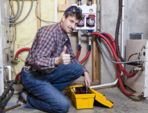 Technician Kneeling In Front Of Furnace With Thumbs Up